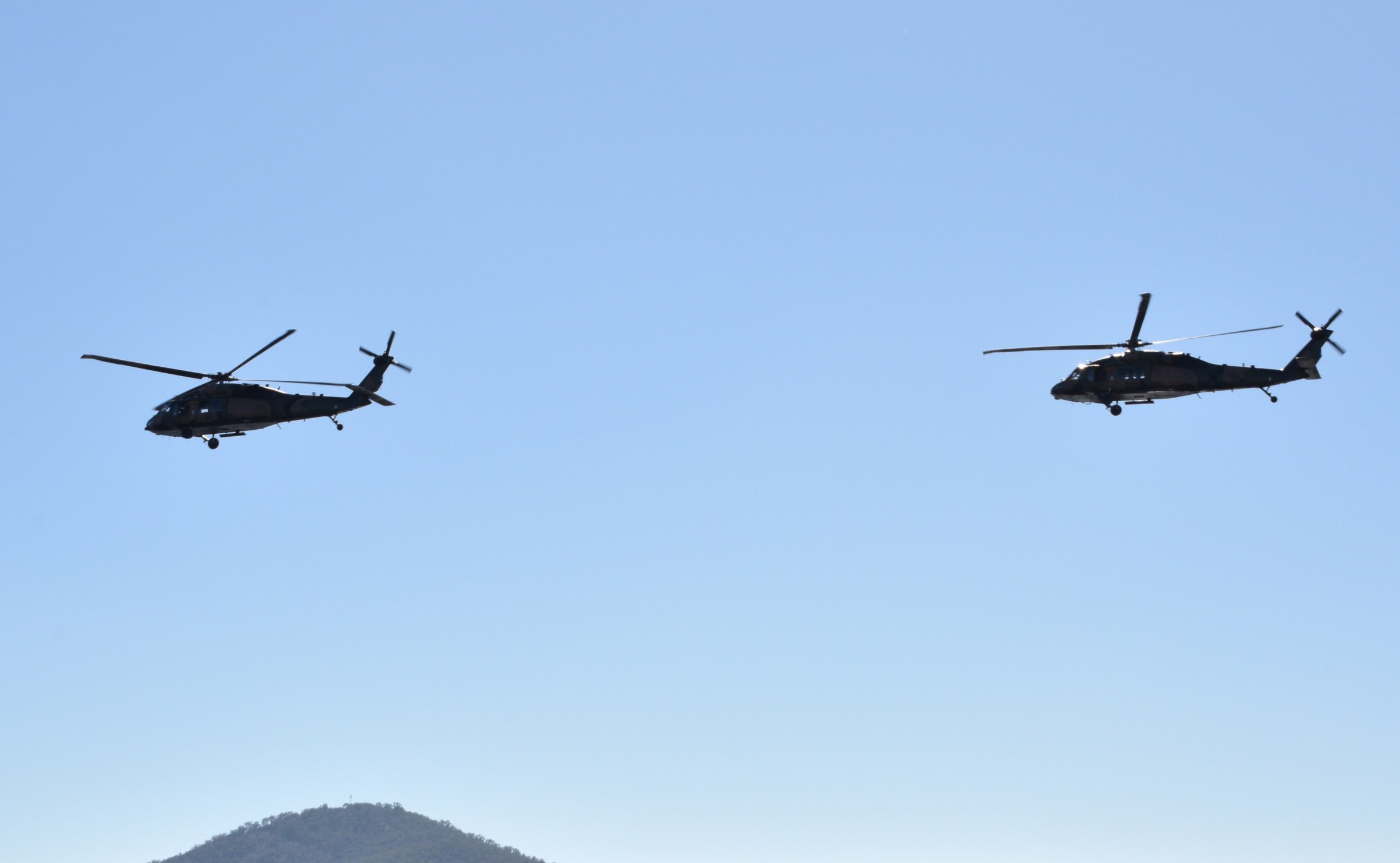 Two Sikorsky UH 60 Black Hawk military helicopters on a low level flight